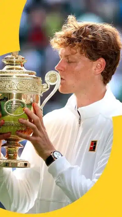 Jannik Sinner kisses the Wimbledon trophy