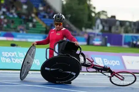 Noemi Alphonse, of Mauritius, picks up her racing wheelchair after the crash