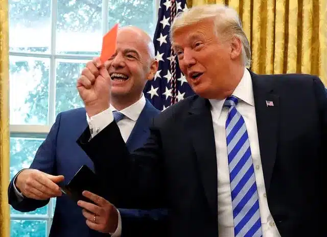 US president Donald Trump holds up a red card as he meets with Fifa counterpart Gianni Infantino before the World Cup