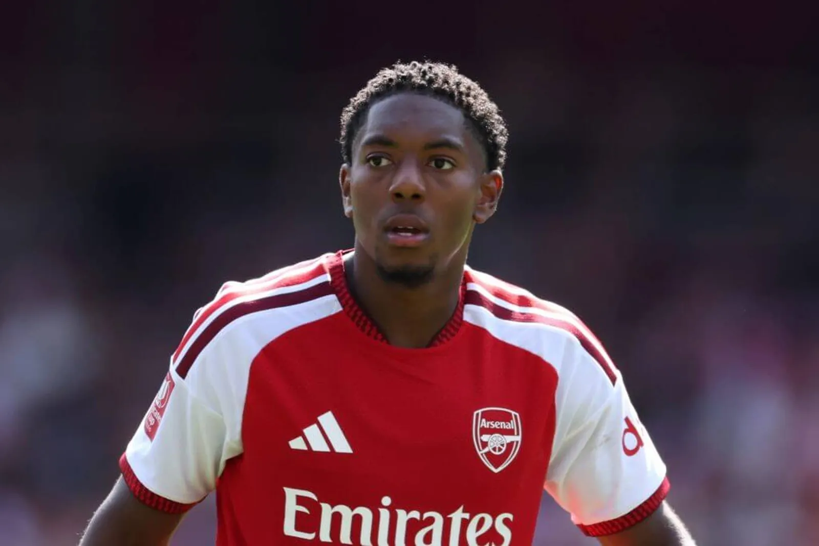 Myles Lewis-Skelly from the waist up, wearing the red home shirt of Arsenal.